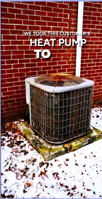 Short-form video frame of an aged outdoor heat pump against a brick wall with on-screen text reading We took this customer's heat pump to